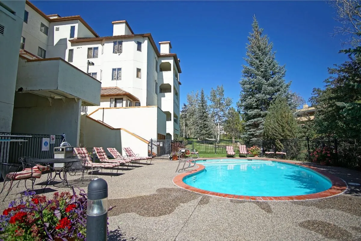 The swimming pool area is surrounded by lounge chairs and greenery, creating a leisurely and refreshing mood. The scene hints at opportunities to relax, socialize, and enjoy resort-style amenities.